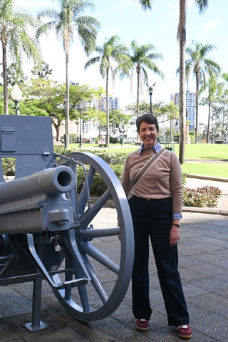 Brisbane Unexpected guides stands beside a German Krupp Field Gun in a large city square.
